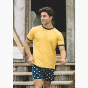 Man wearing yellow shirt and blue slim fit boxers with white dots.