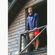 Man standing on balcony wearing a navy hoodie