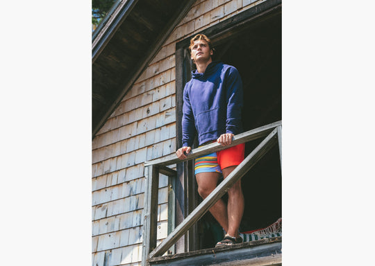 Man standing on balcony wearing a navy hoodie
