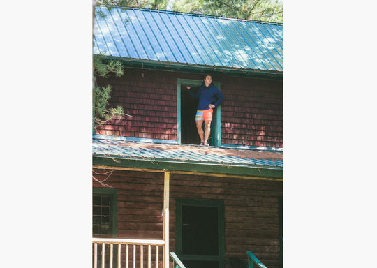 Man standing on roof wearing navy hoodie