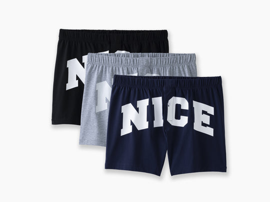 Three pairs of slim fit boxers with the word "NICE" on front in big white bold front. There are navy blue, heather grey, and black pairs laid flat on light grey backround.