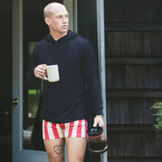 Man in lounge hoodie and cabana slim fit boxers on front porch.