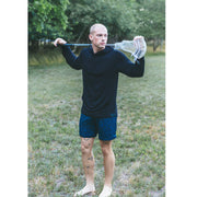 Man standing in grassy field wearing a black hoodie.