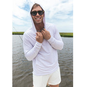 Man smiling standing on a boat wearing linen stripe hoodie and sunglasses.