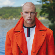 Man standing in orange jacket and vintage ringer t.
