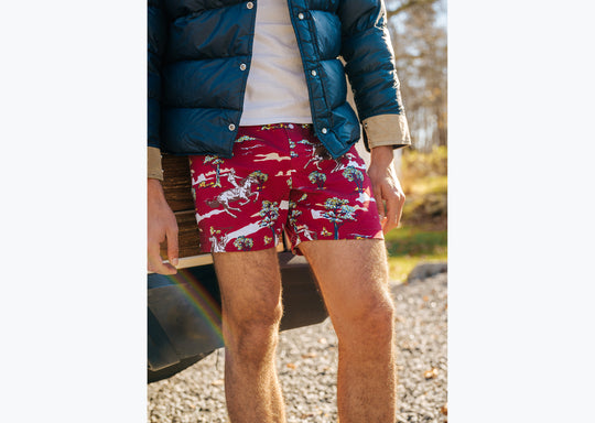 Close up of man standing in front of wagoneer wearing blue jacket and red slim fit boxers with horses, clouds, and trees printed on.