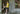 Man standing in doorway wearing yellow polo and black "schooner" print mesh lounge shorts.