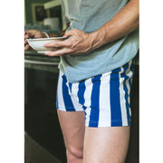 Man wearing blue and cream stripe slim fit boxer and gray shit holding a bowl to eat out of.