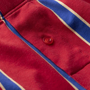 Close up detail shot of red/blue/yellow stripe slim fit boxer with red button.