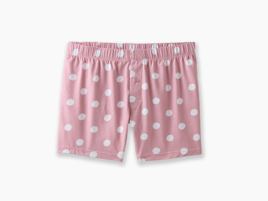 Pink slim fit boxers with white hand drawn dots sitting on a light grey background.