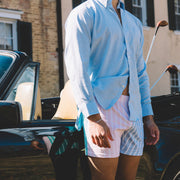 Man standing in front of car and house wearing Pastel Stripe slim fit boxer and light blue dress shirt.