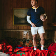 Man in ringer t shirt and lounge shorts in cabin.