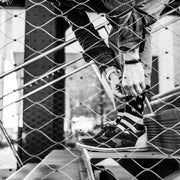 Man bending down on some stairs to fix Nice Laundry american flag socks shot in a black in white photo.