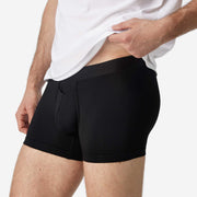 Close up side view of man wearing black boxer brief.