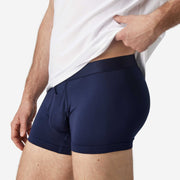 Close up side view of man wearing navy blue boxer brief.
