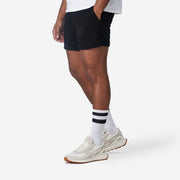 Side view of mean wearing black lounge short with hand in pocket.
