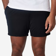 Close up view of mean wearing black lounge short with hand in pocket.