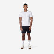 Man standing with hands at side wearing black lounge short.