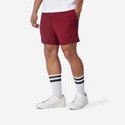Close up view of man wearing burgundy lounge short with hand in pocket.