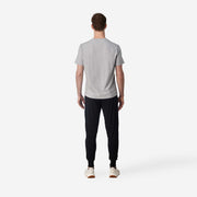 Full body back shot of man wearing black cloud pant with grey t-shirt.