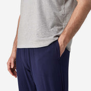 Close up side view of man wearing blue cloud pant with hand in pocket.