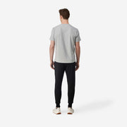 Full body back view of man wearing black lounge pants.