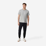 Full body front view of man wearing black lounge pants.