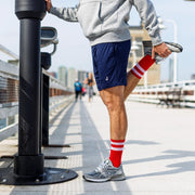 Man stretching in lounge shorts with J embroidery.