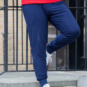 Man wearing cloud pants leaning against a railing.