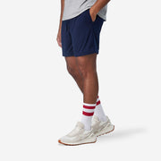 Side view shot of man wearing navy blue lounge short with hand in pocket.