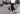 Man wearing black lounge pants and white hoodie on the sidewalk.