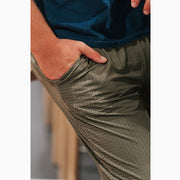 Man putting hands in the pocket of his olive lounge pants.