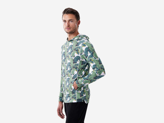 Side shot of man wearing a palms print hoodie.
