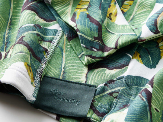 Close up detail shot of the sleeves and tag of a palms print hoodie.