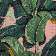 Close up detail shot of pink mesh material with palm leaves printed on it.