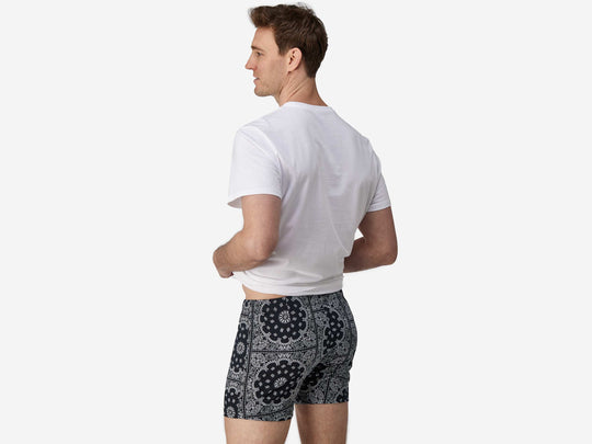 Back side view of man wearing black bandana slim fit boxers & white t-shirt.