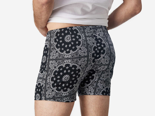 Close up back view of man wearing black bandana slim fit boxers & white t-shirt.
