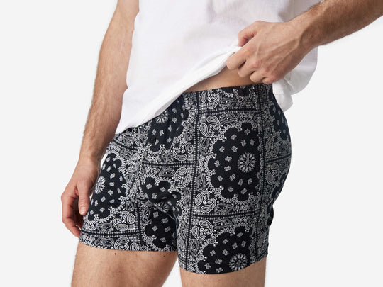 Close up side view of man wearing black bandana slim fit boxers & white t-shirt.