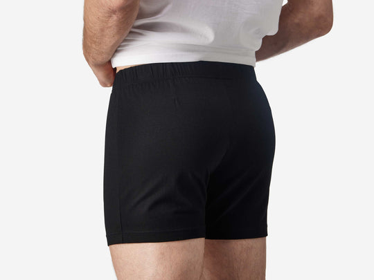 Close up back view of man wearing black slim fit boxer and white t-shirt.