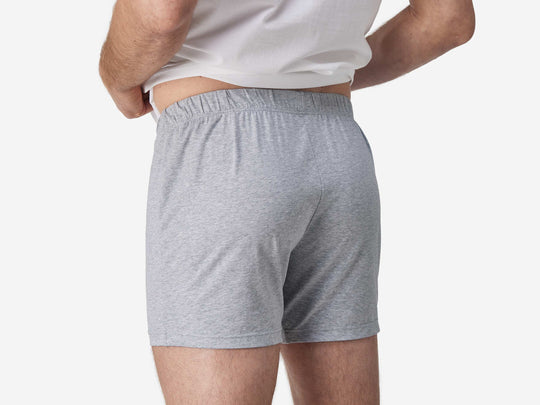 Close up back view of man wearing gray slim fit boxer and white t-shirt.