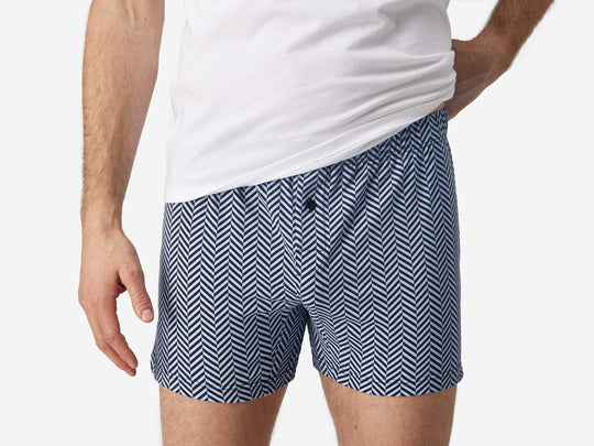 Front view close up shot of man wearing blue herringbone slim fit boxers and white t-shirt.