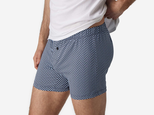 Close up side view shot of man wearing blue herringbone slim fit boxers.