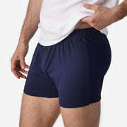 Close up side view of man wearing navy blue slim fit boxer and white t-shirt.