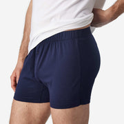Close up side view on man wearing navy blue slim fit boxers and white t-shirt.