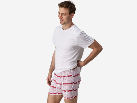 Body side view of man wearing red & white printed "thank you" slim fit boxers & white t-shirt.