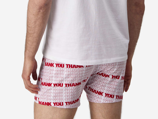 Close up back view of man wearing red & white printed "thank you" slim fit boxers & white t-shirt.