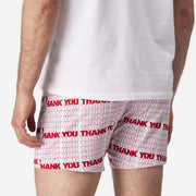 Close up back view of man wearing red & white printed "thank you" slim fit boxers & white t-shirt.