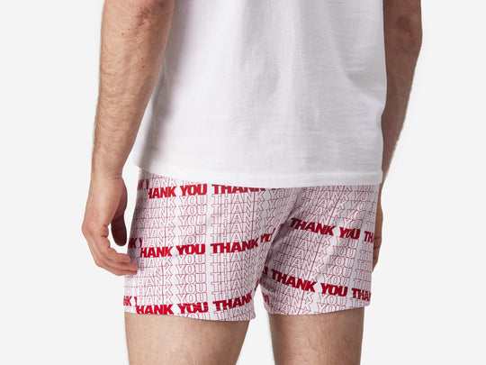 Close up back view of man wearing red & white printed "thank you" slim fit boxers & white t-shirt.