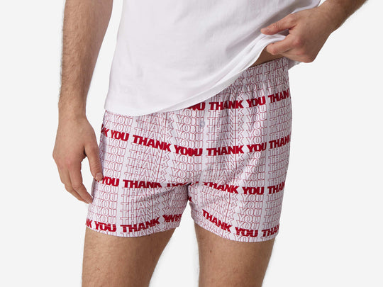 Close up front view of man wearing red & white printed "thank you" slim fit boxers & white t-shirt.