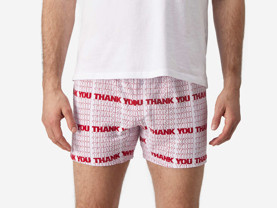 Close up front view of man wearing red & white printed "thank you" slim fit boxers & white t-shirt.
